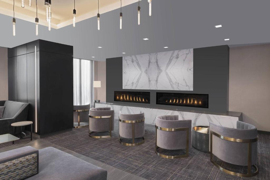 a lobby with a bar with stools and a fireplace at Courtyard by Marriott Halifax Dartmouth in Halifax