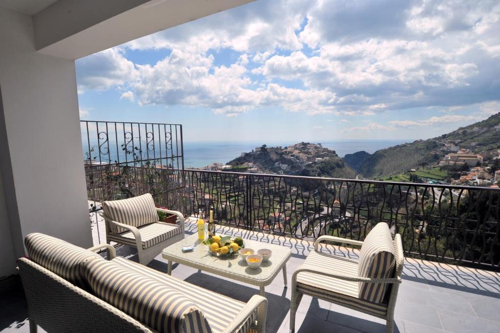 a balcony with chairs and a table with a view at Colpo d Ali - Amazing view and Jacuzzi in Ravello in Ravello