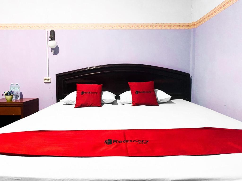 Palopo的住宿－RedDoorz near Terminal Dangerakko Palopo，一张带红色枕头和红色毯子的床