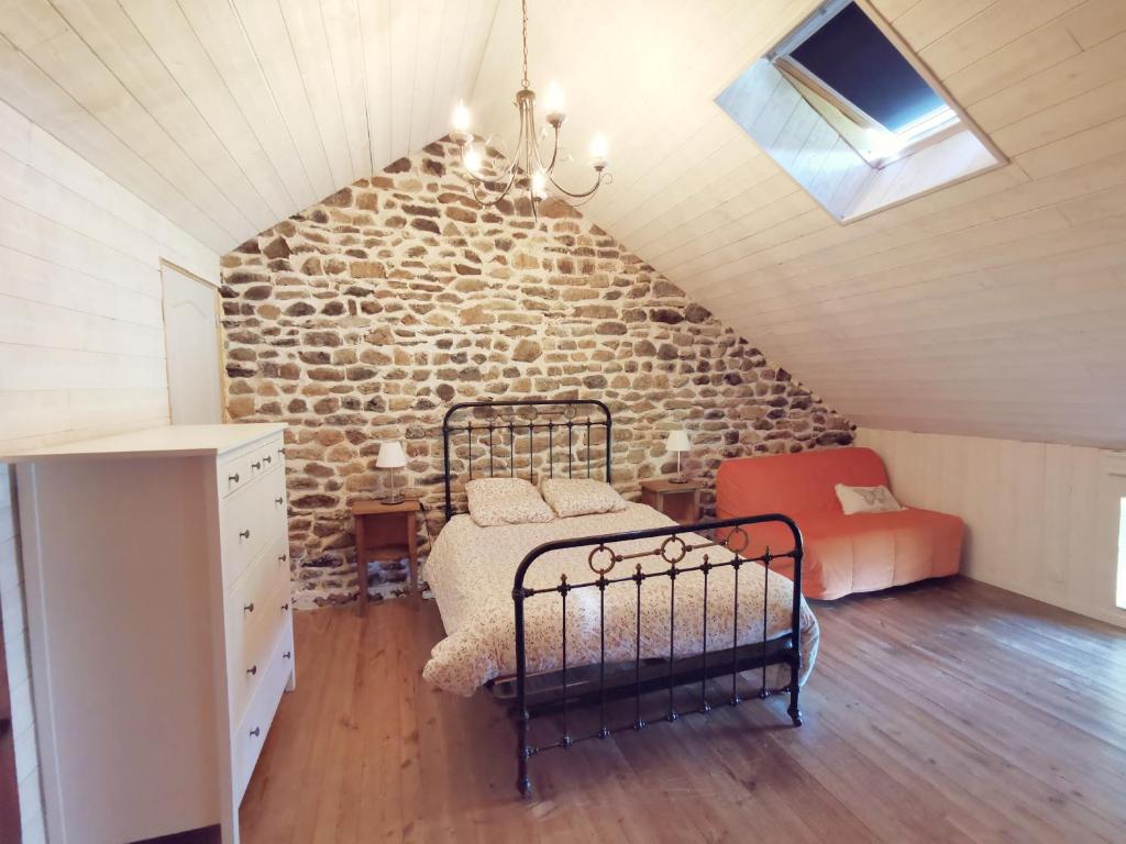 a bedroom with a bed and a stone wall at La Maison des Biscuits in Loubaresse