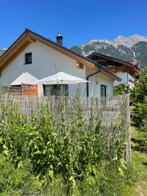 ein Haus mit einem Regenschirm hinter einem Zaun in der Unterkunft Mein Chalet in Leutasch