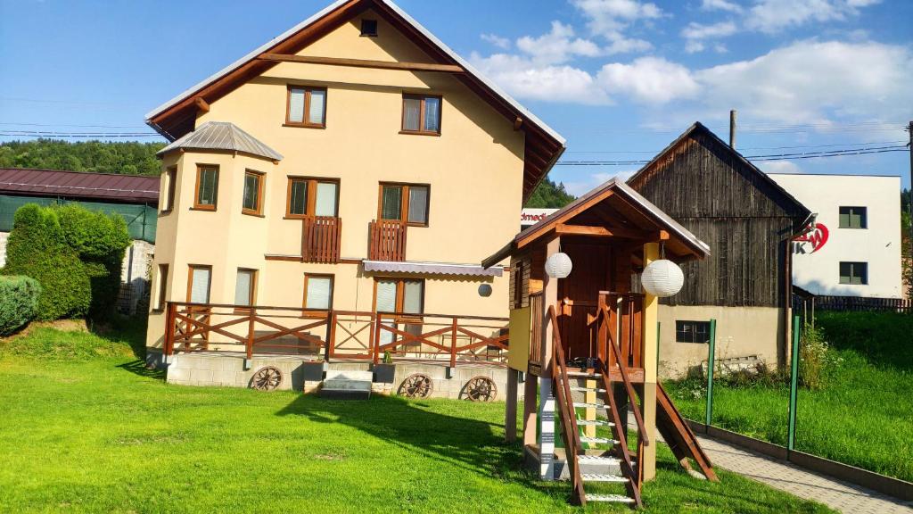 a large house with a play structure in front of it at Ubytovanie u Grošíka in Oščadnica