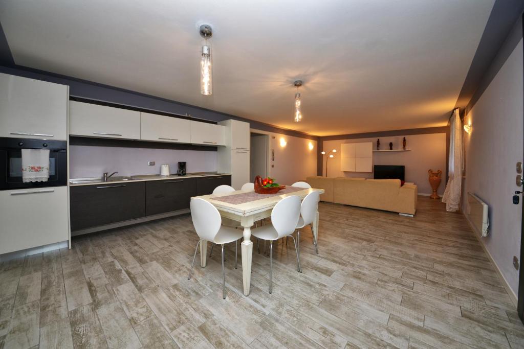eine Küche und ein Esszimmer mit einem Tisch und Stühlen in der Unterkunft Appartamento Enrichetta in Manerba del Garda
