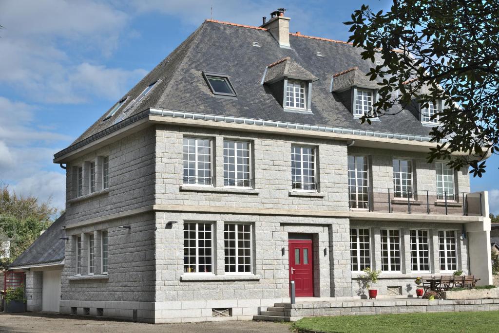 a large brick house with a red door at Manoir de Kerguestenen in Gestel