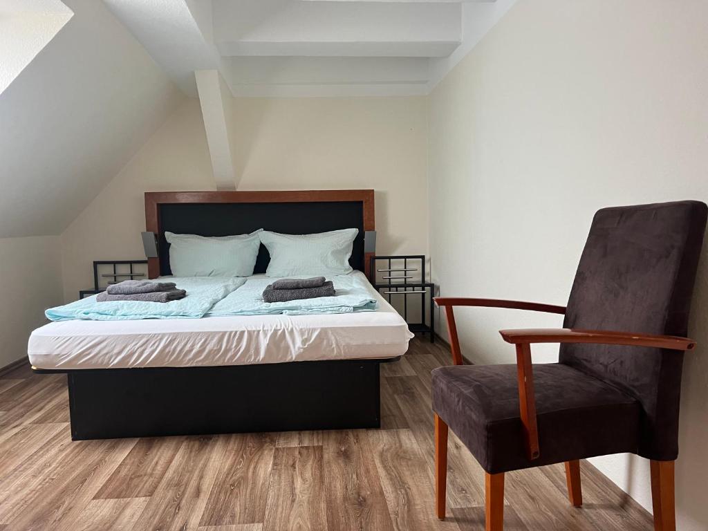a bedroom with a bed and a chair at Apart Pension Plaue in Brandenburg an der Havel