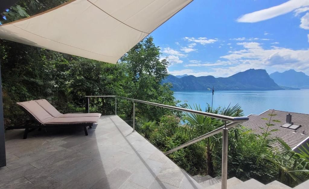 einen Balkon mit einem Stuhl und Blick auf das Wasser in der Unterkunft Villa Bootsmann mit spektakulärer Seesicht und Badeplatz in Vitznau