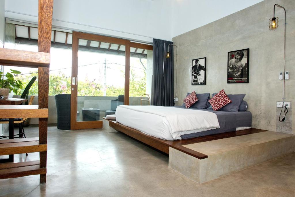 a bedroom with a bed and a living room at Sammy's Canggu in Canggu