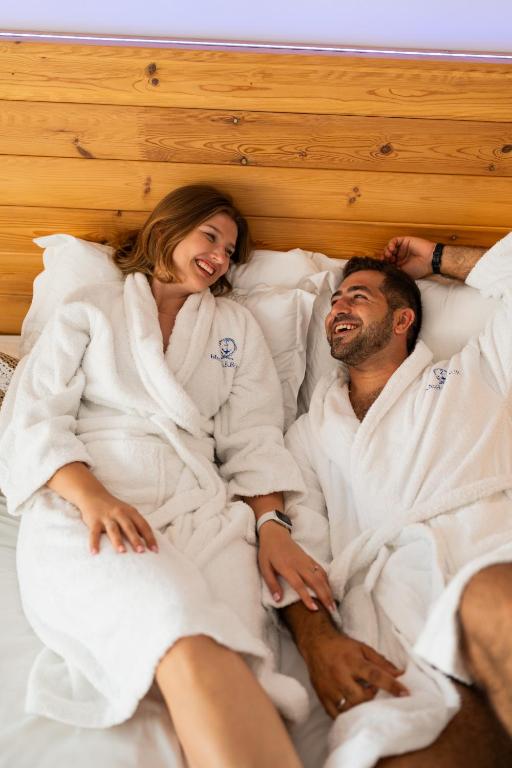 a man and woman laying in bed in towels at Blue Harbour Boutique in Ayia Napa