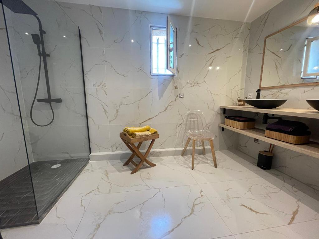 a bathroom with a shower and a sink and a stool at Le Val d'escure in Saint-Raphaël