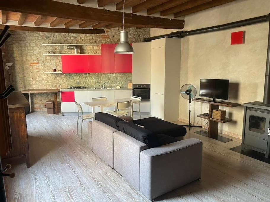 uma sala de estar com um sofá, uma mesa e uma cozinha em Casa in piazzetta em Rivergaro