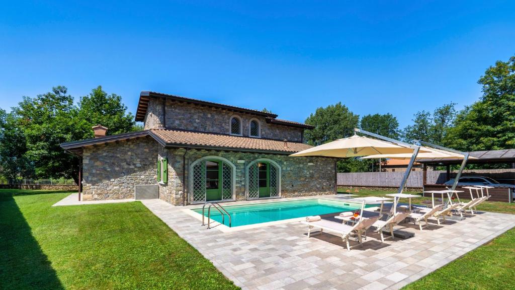 a swimming pool in front of a stone house at Villa Elsa 6, Emma Villas in Filetto
