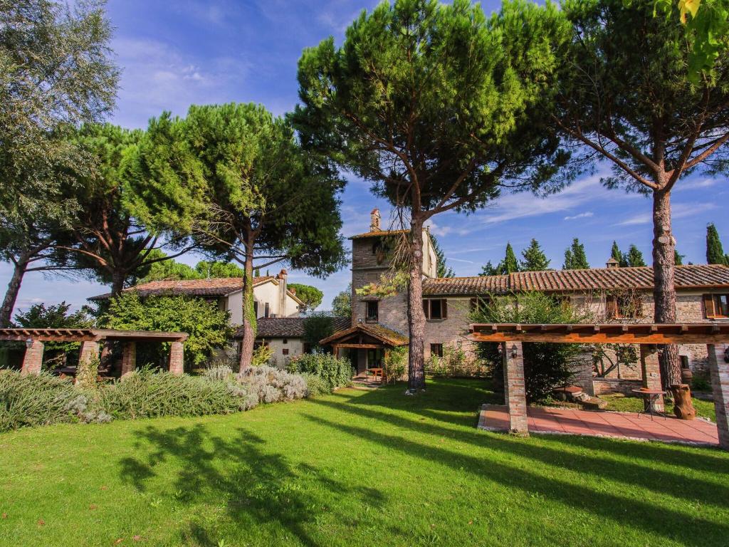 uma vista exterior de uma casa com árvores em Farmhouse in Marsciano with vineyards olive groves em Marsciano