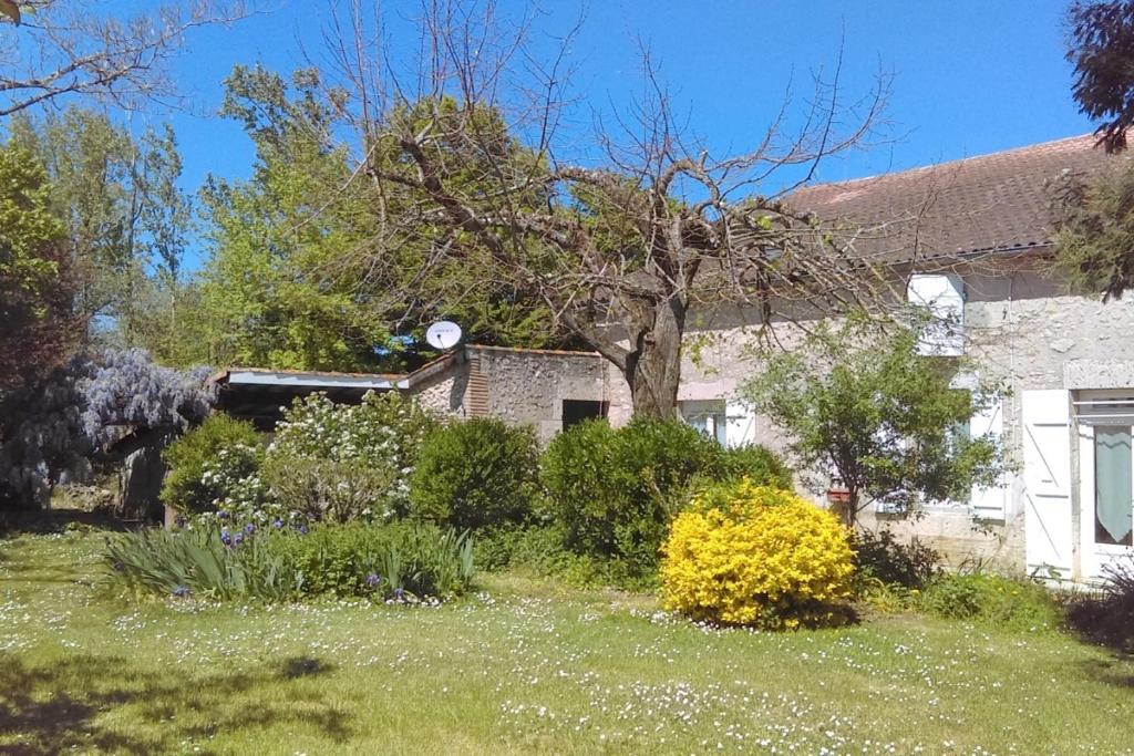 una casa con un patio con flores y plantas en Les Glycines, en Saint-Pierre-de-Buzet