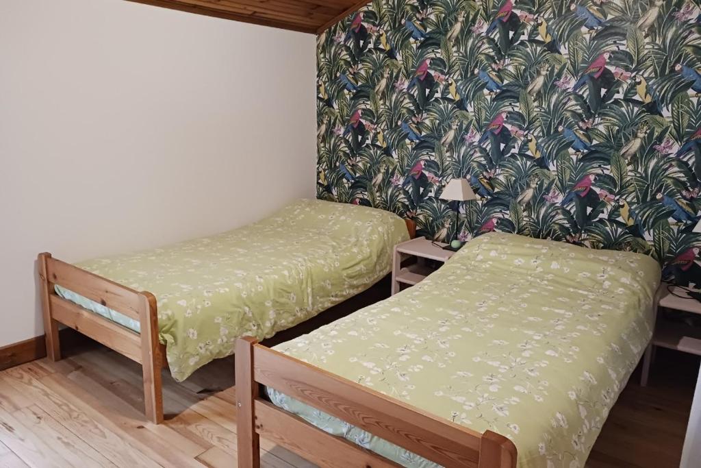 a room with two beds and a wallpaper at Les Glycines in Saint-Pierre-de-Buzet