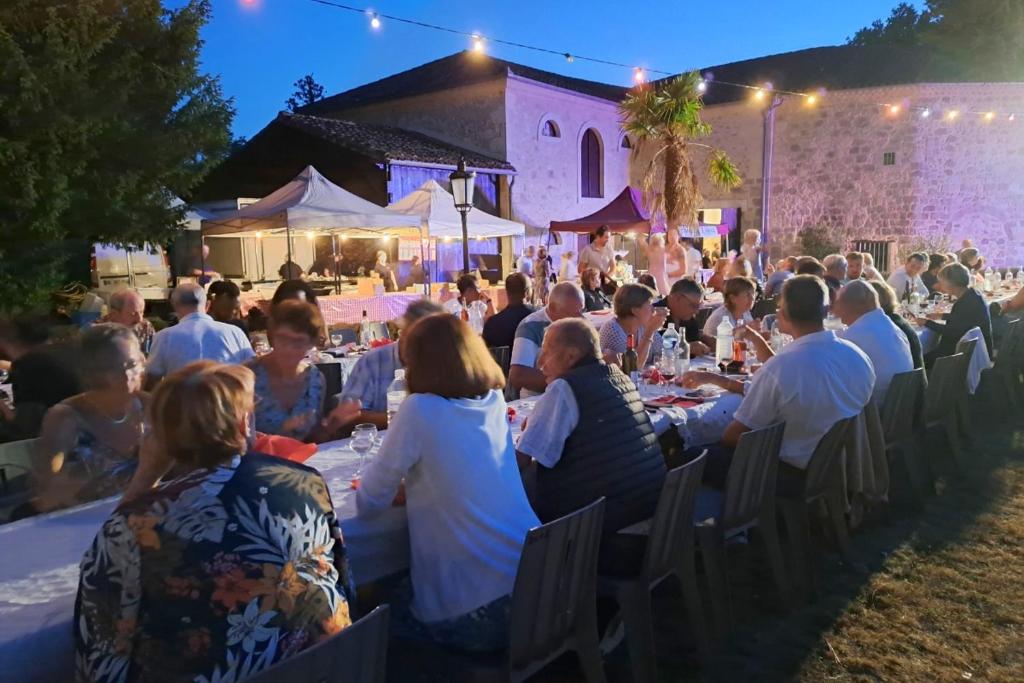 a group of people sitting at tables at a party at Les Glycines in Saint-Pierre-de-Buzet