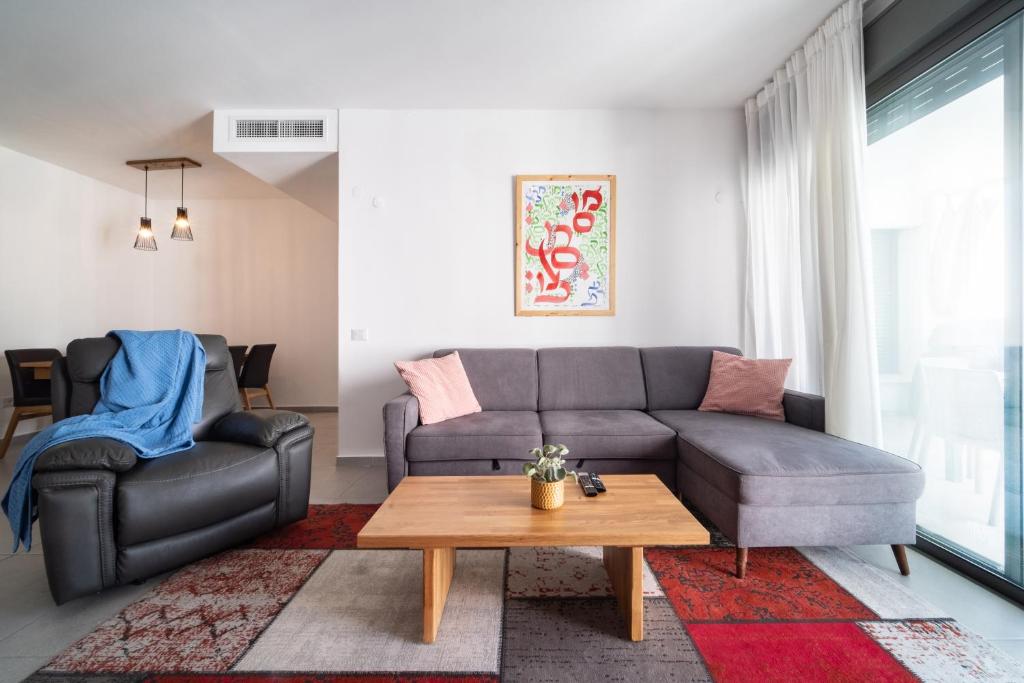 uma sala de estar com um sofá e uma mesa em Achziv Beach Haven 3BR Apartment by Sea N' Rent em Nahariya