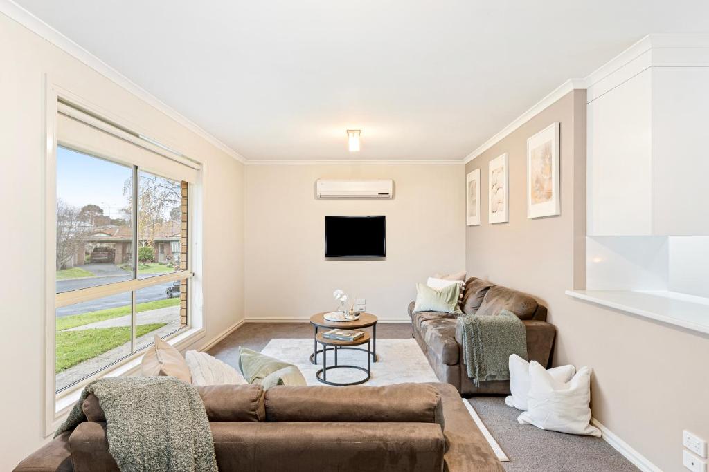 ein Wohnzimmer mit 2 Sofas und einem TV in der Unterkunft Eudor House in Mount Gambier