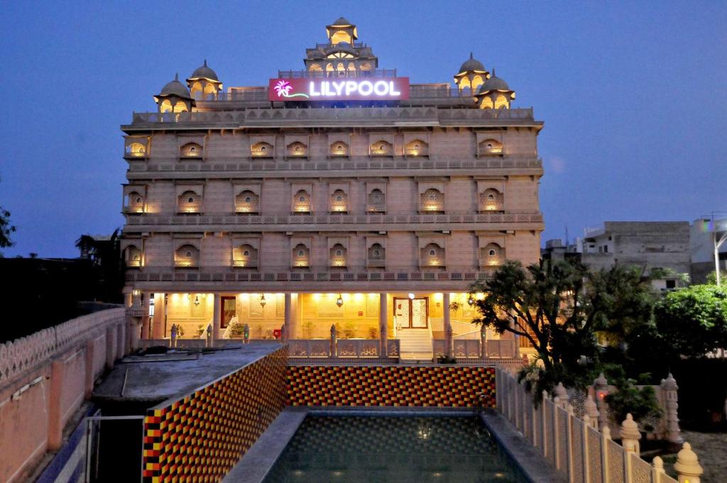 a large building with a pool in front of it at Lilypool - The Heritage Jalmahal in Jaipur