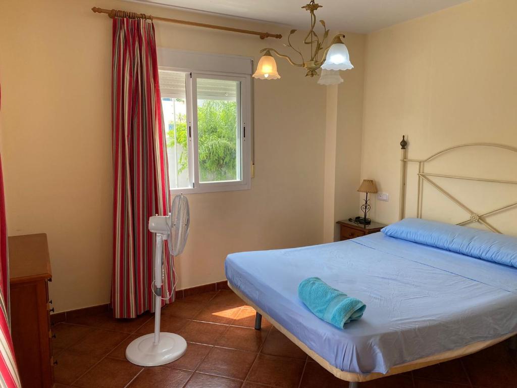 1 dormitorio con cama y ventana en Casa KIKO, LA CASA ESTA EN LA ANTILLA 200METROS PLAYA, en La Antilla