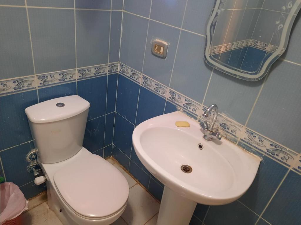 ein Badezimmer mit einem weißen WC und einem Waschbecken in der Unterkunft شاليه راقي بمارسيليا بيتش 1 الساحل in Dawwār Muḩammad Abū Shunaynah
