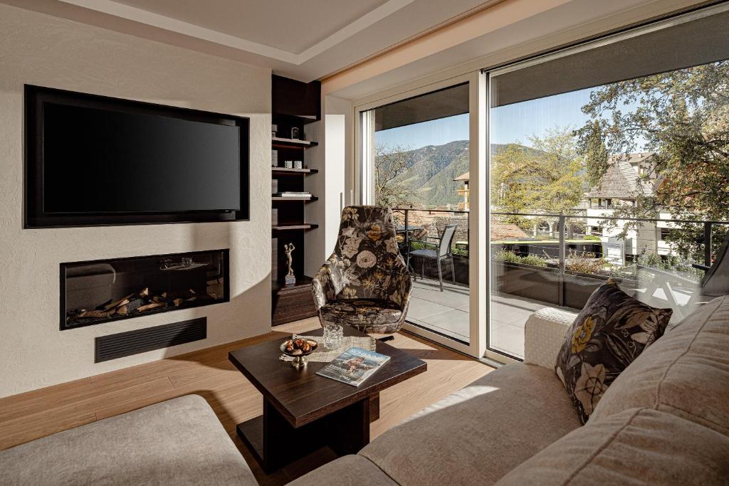 een woonkamer met een open haard en een televisie bij Schenna Chalet - Apt Stefan in Schenna