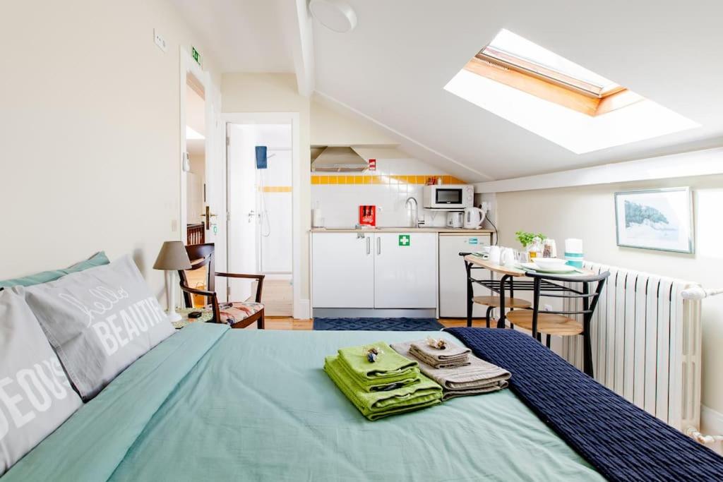 um quarto com uma cama e uma cozinha com uma mesa em skyaccommodations Studio 3+ kitchen and double bed em Coimbra