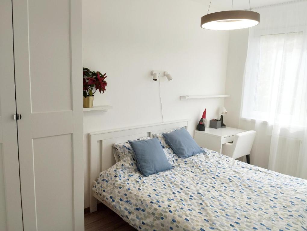 a bedroom with a bed with blue pillows on it at Forest Hill apartment in Budapest