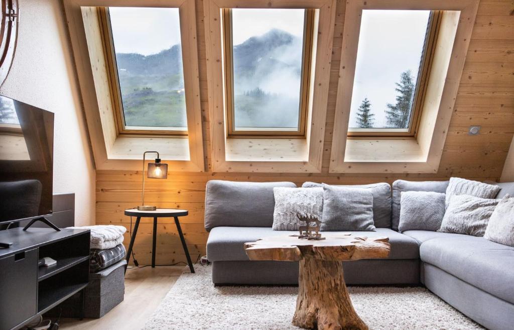 - un salon avec un canapé et quatre fenêtres dans l'établissement IMMODREAMS - L'ours polaire, à Morzine