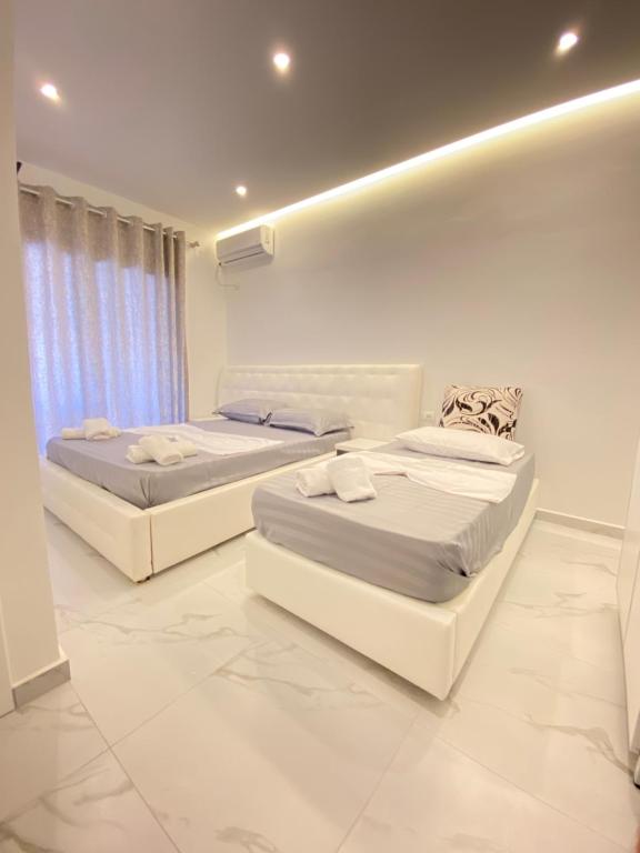 2 letti in una camera con pareti bianche di Villa Mucodemi 1 a Ksamil