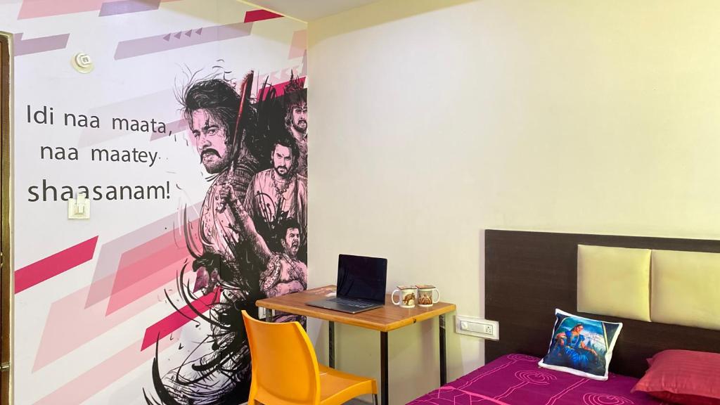 C Suites - Richfield في بانغالور: غرفة مع مكتب وجهاز كمبيوتر محمول على الحائط