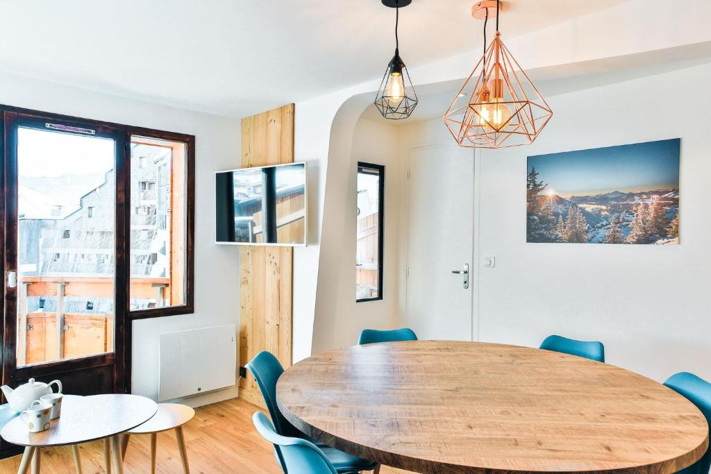 une salle à manger avec une table et des chaises en bois dans l'établissement IMMODREAMS - Les Dents Blanches, à Avoriaz