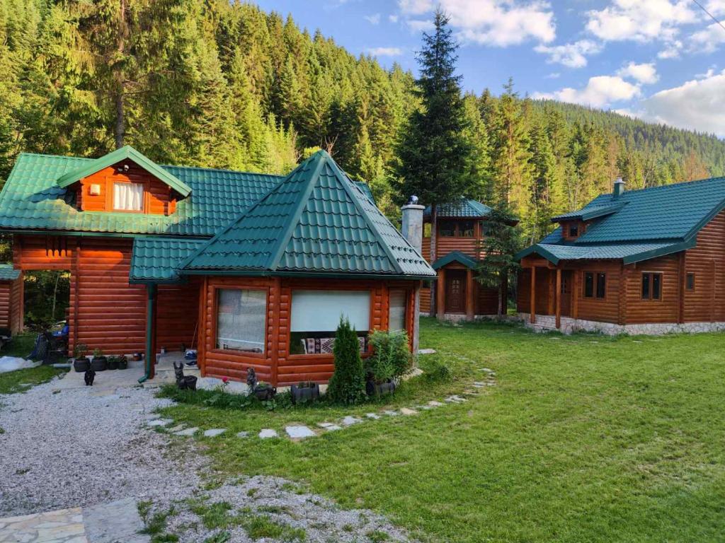 une cabane en rondins avec un toit vert dans une cour dans l'établissement Brvnara Ibar, à Rožaje