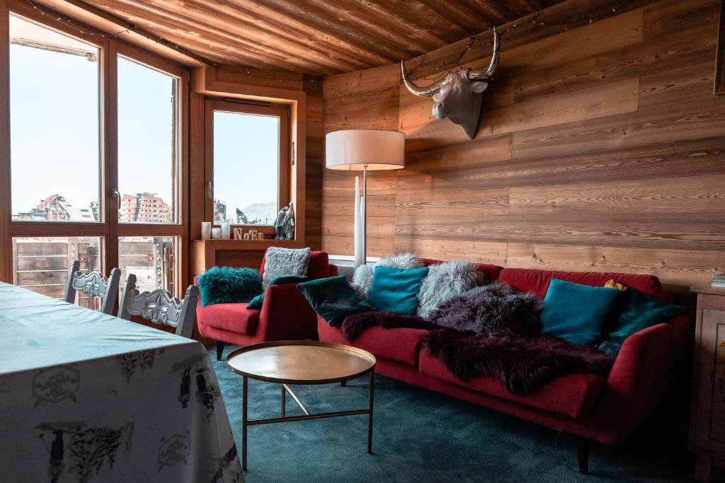 - un salon avec un canapé rouge et des oreillers bleus dans l'établissement IMMODREAMS - Le Lodge, à Avoriaz