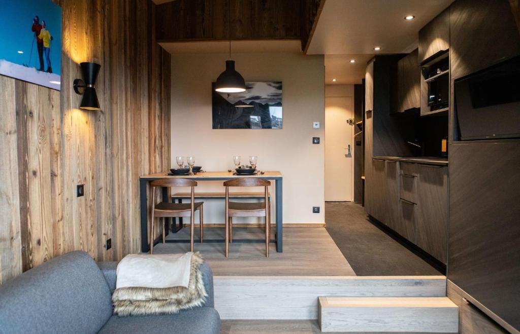 une cuisine et une salle à manger avec une table et des chaises dans l'établissement IMMODREAMS - La Cabane, à Morzine