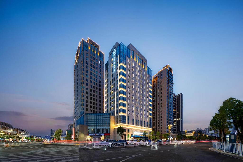 un grupo de edificios altos en una ciudad por la noche en Atour Hotel Dali Erhai Park, en Dali