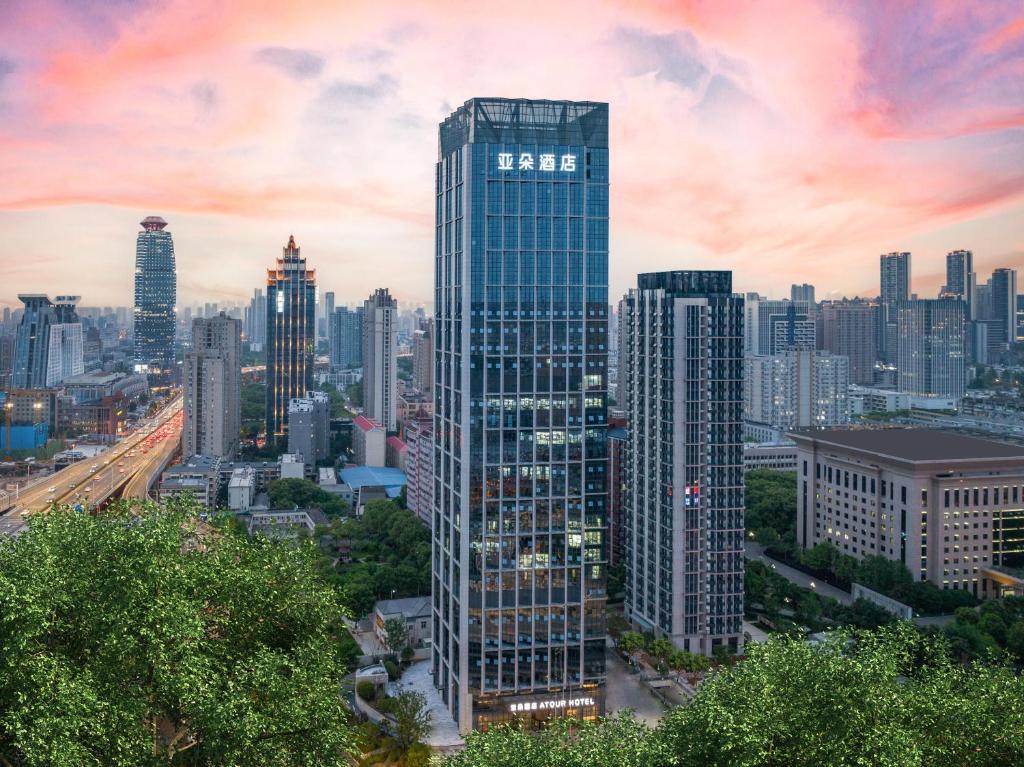 een hoog gebouw met een bord erop in een stad bij Atour Hotel Wuhan University of Technology Jiedaokou in Wuhan