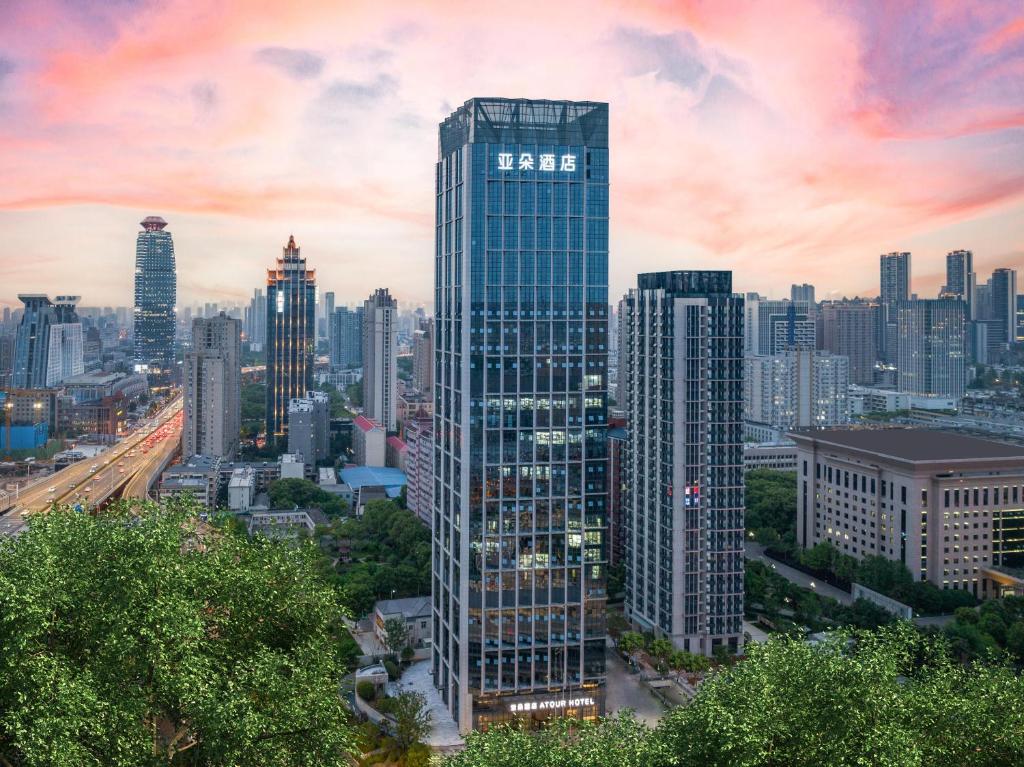 a tall building with a sign on it in a city at Atour Hotel Wuhan University of Technology Jiedaokou in Wuhan