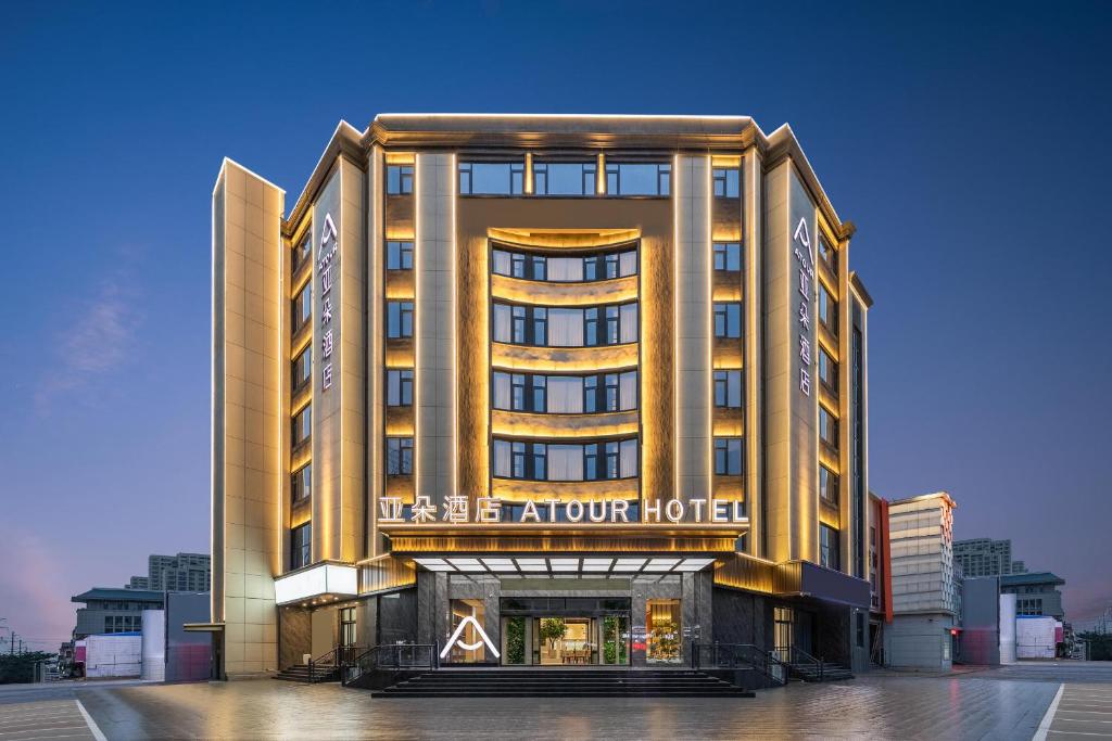 een hotelgebouw met een bord dat akvation hotel leest bij Atour Hotel Linqing City Center Liaocheng in Linqing