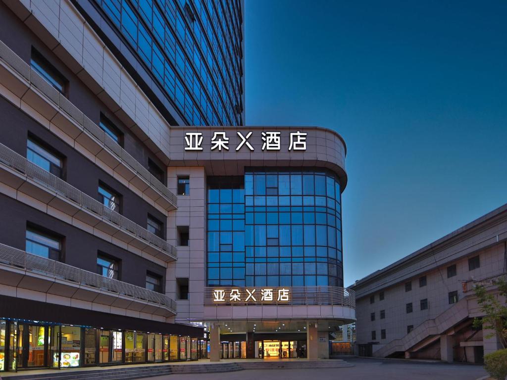 un edificio con un cartel en el costado en Atour X Hotel Changchun Railway Station, en Changchún