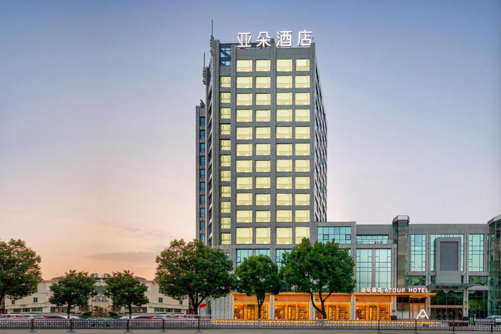 台州市にあるAtour Hotel Luqiao Taizhouの看板が上がる高層ビル