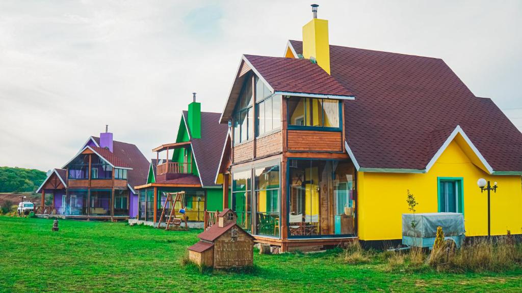 una fila de casas coloridas en un campo en Karaçam & Yedigöller doğa evleri, en Kemaller