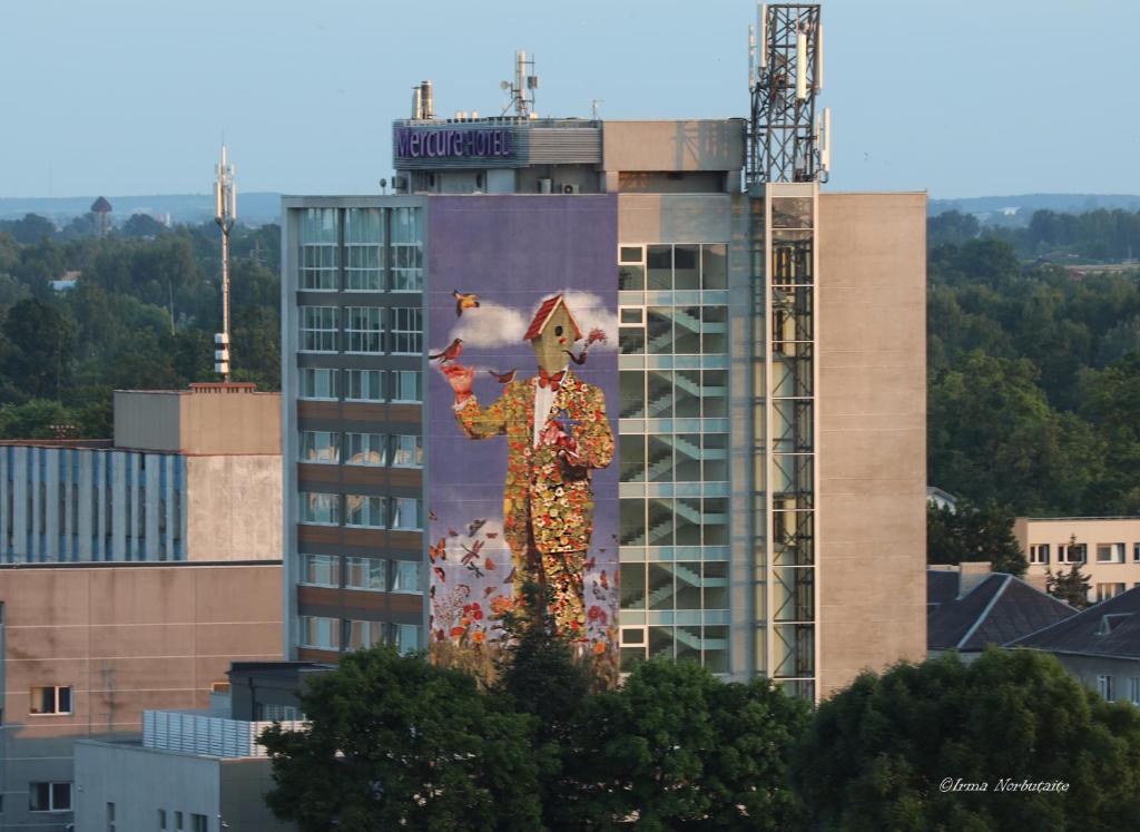 a building with a large painting on the side of it at Mercure Marijampole in Marijampolė