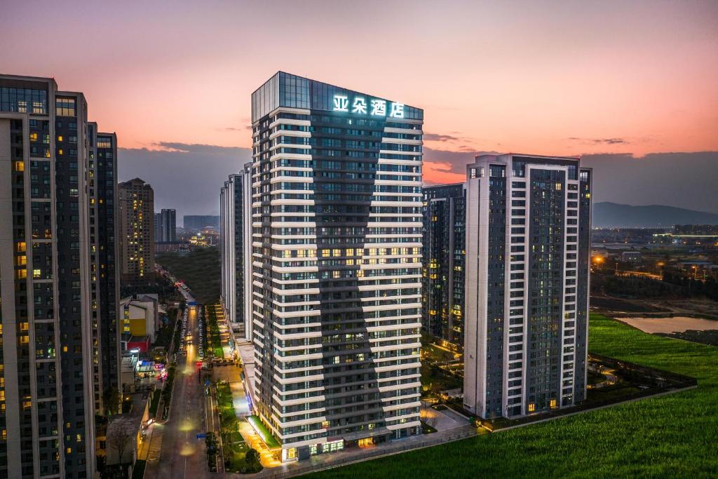 a city skyline with tall buildings at dusk at Atour Hotel Kunming Guangfu Road Haile World in Kunming