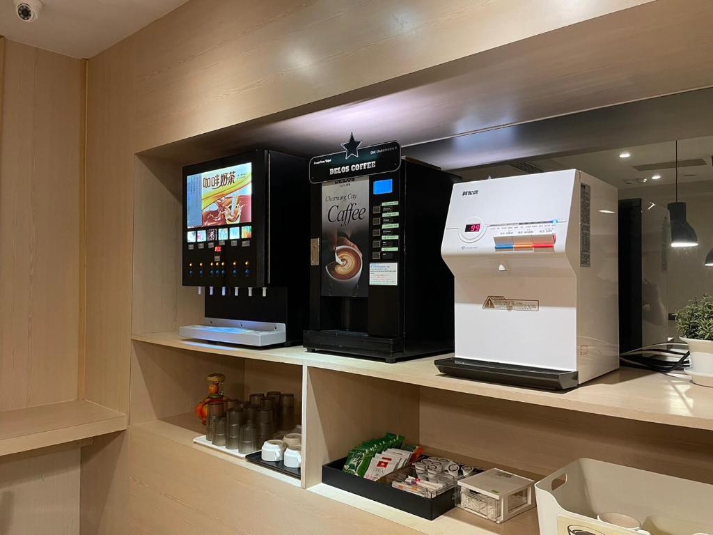 a kitchen with a microwave and a coffee machine on a shelf at Yomi Hotel - ShuangLian MRT in Taipei