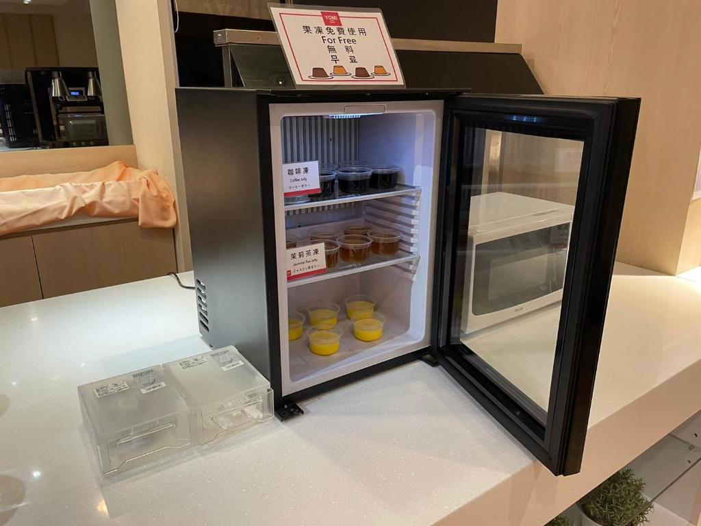 a black refrigerator with food inside of it at Yomi Hotel - ShuangLian MRT in Taipei