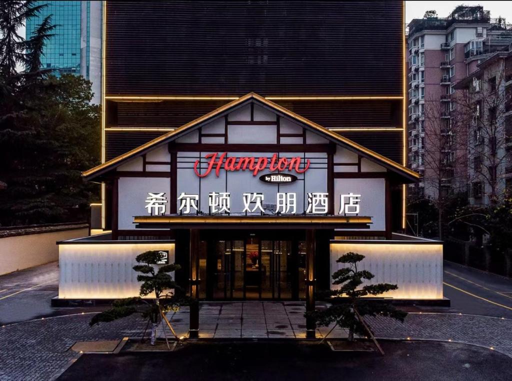 a building with a sign on the front of it at Hampton by Hilton Hangzhou West Lake in Hangzhou