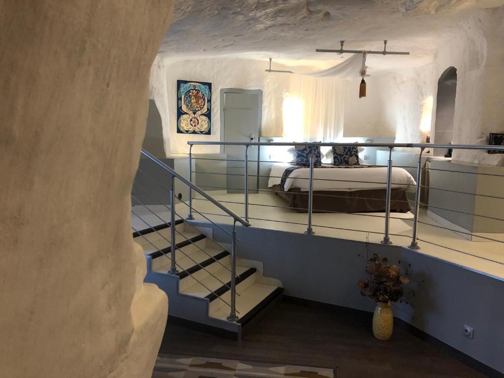 Logis Hôtels Troglododo في آزاي-لو-ريدو: غرفة نوم مع سرير بطابقين في كهف