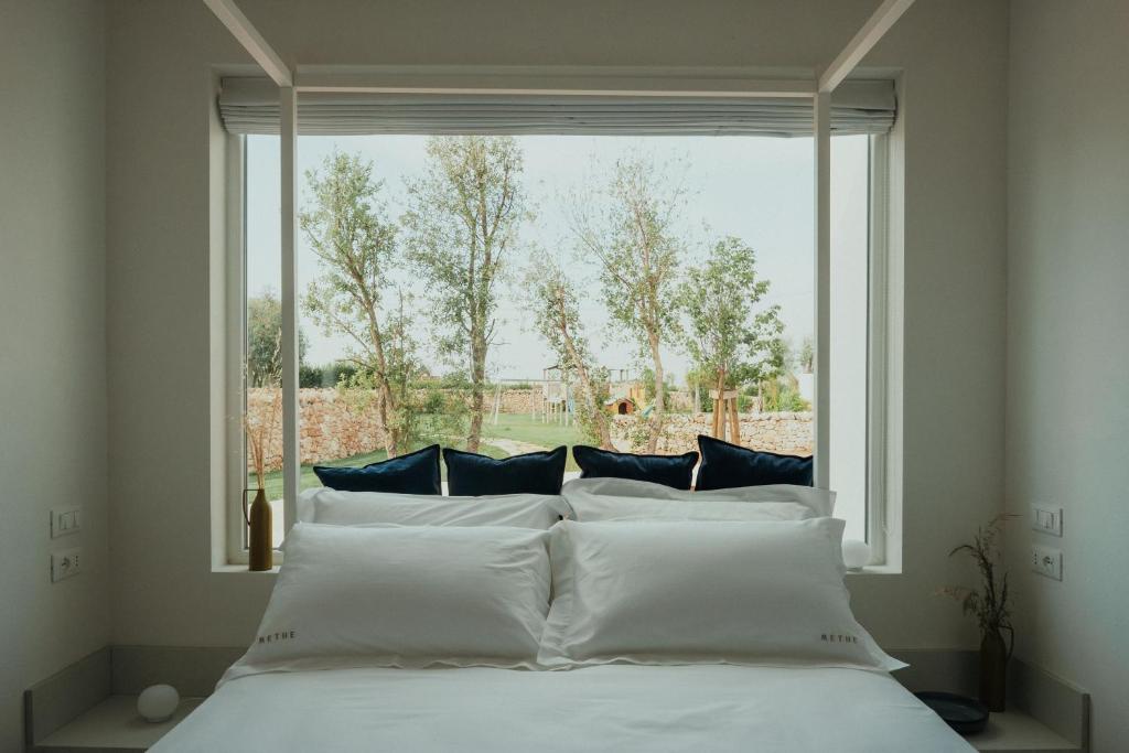 Schlafzimmer mit einem Bett und einem großen Fenster in der Unterkunft Methe in Lizzano