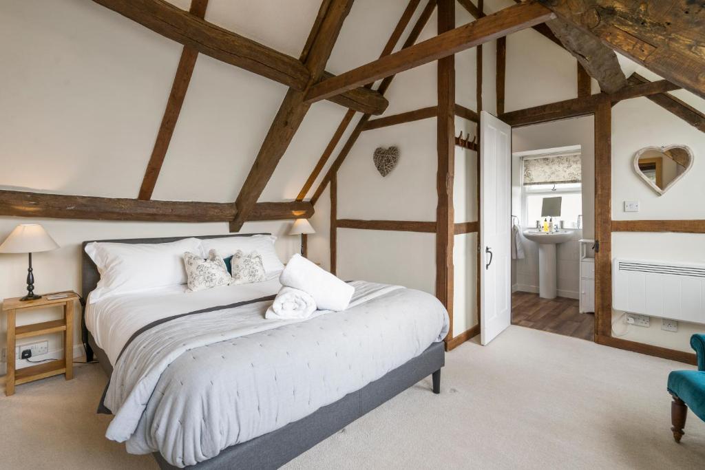 a bedroom with a bed in a room with wooden ceilings at Box Cottage in Broadwell