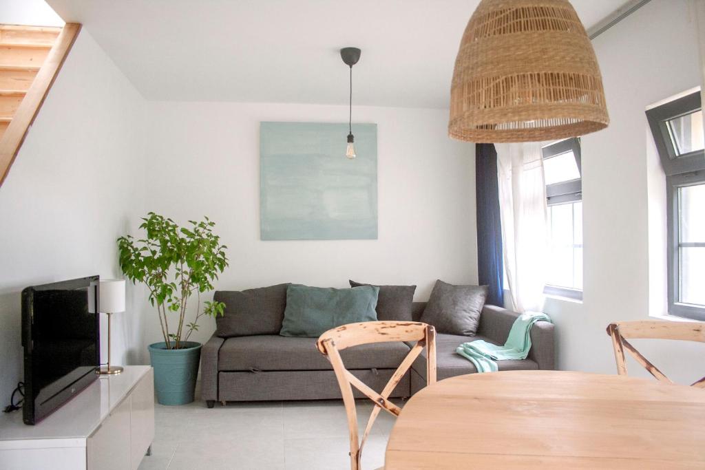 uma sala de estar com um sofá, uma mesa e cadeiras em Maison calme - Frontière Montagne et Plage em Urrugne